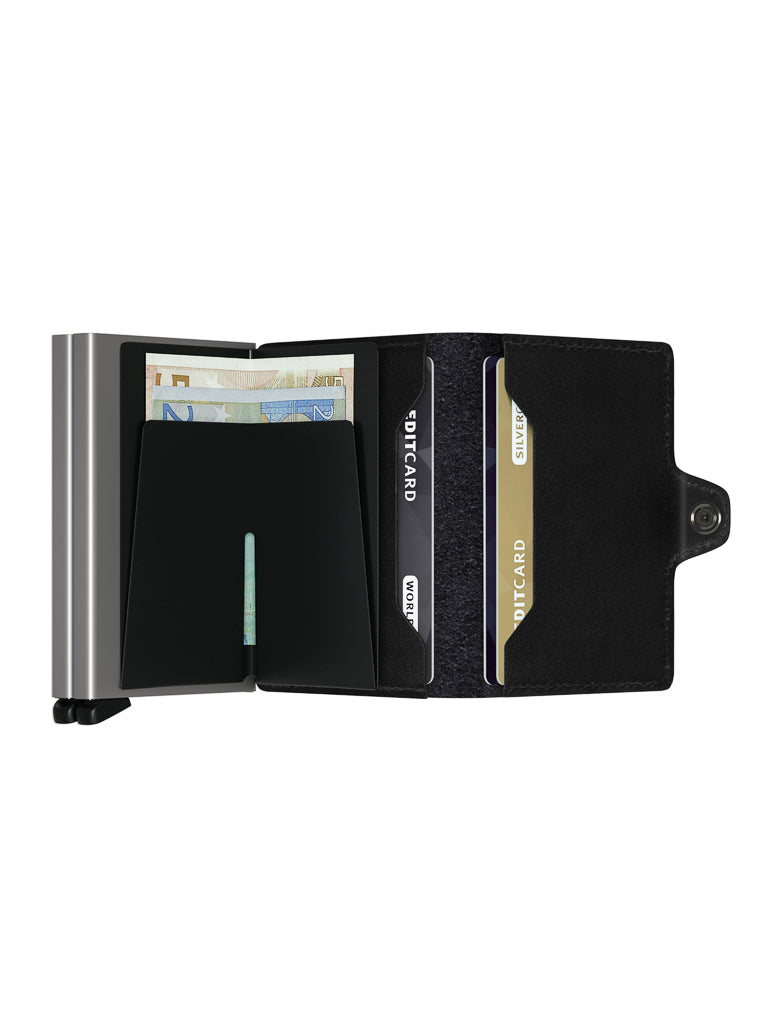 The Secrid Twin Wallet Original Compact by Secrid, a black leather RFID wallet with a snap closure, is open on a white background, showing several cards, euro banknotes, and a metal-edged cardholder.