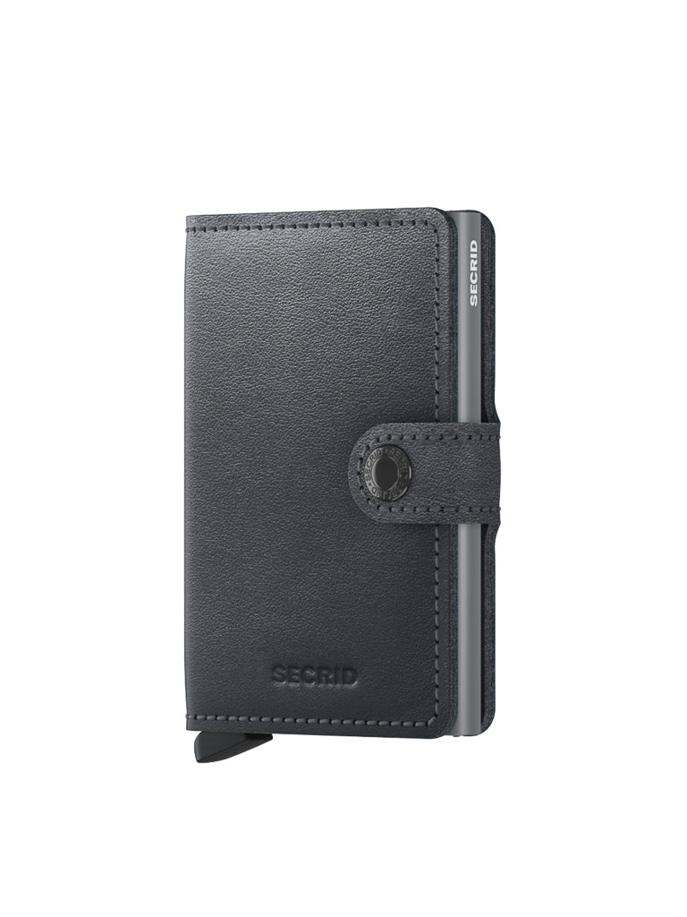 The Secrid Miniwallet Original by Secrid, in black leather with a snap closure, stands upright against a white background. This compact wallet includes subtle stitching, RFID protection, and a small embossed logo on the front.