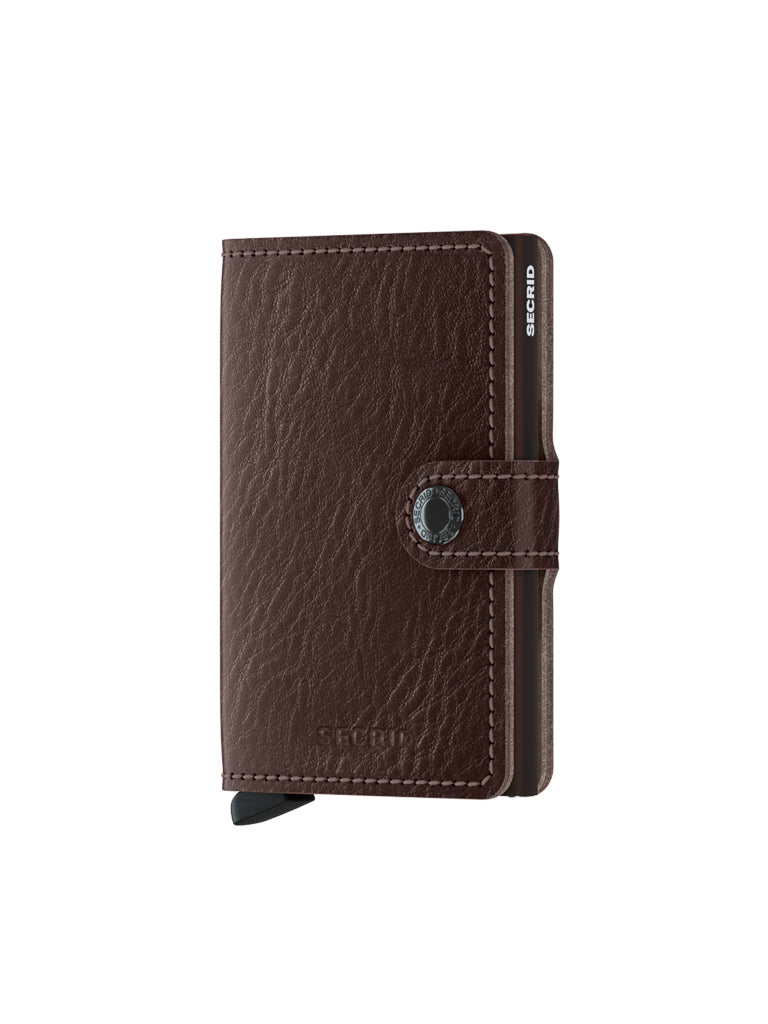The Secrid Miniwallet Vegetable Tanned Leather is a brown wallet with textured, vegetable-tanned leather, a snap-button closure, and a visible black card slider, shown on a white background.
