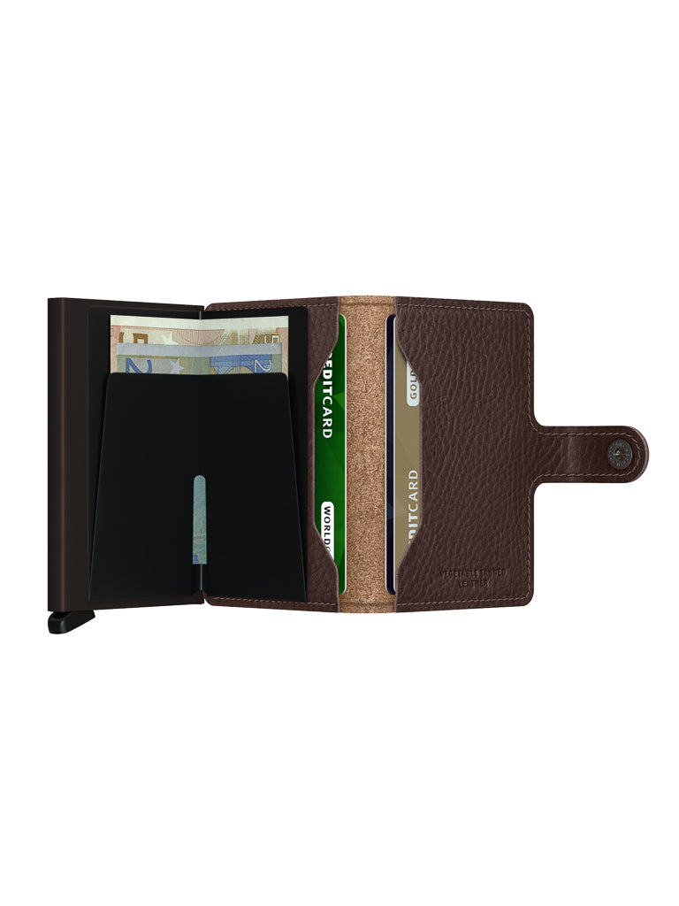 The Secrid Miniwallet Vegetable Tanned Leather in brown features a snap closure and opens to reveal euro notes, two green credit cards, and a gray card arranged in slots. It offers convenient storage and built-in RFID protection.