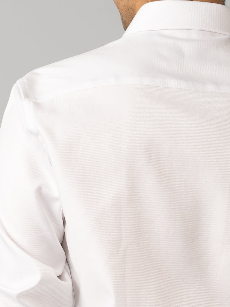 Close-up of the back of a person wearing the ID Menswear Cotton Dress Shirt in Slim Fit, highlighting the shoulder and upper back. The plain gray background and the cropped view keep the head and front out of sight.