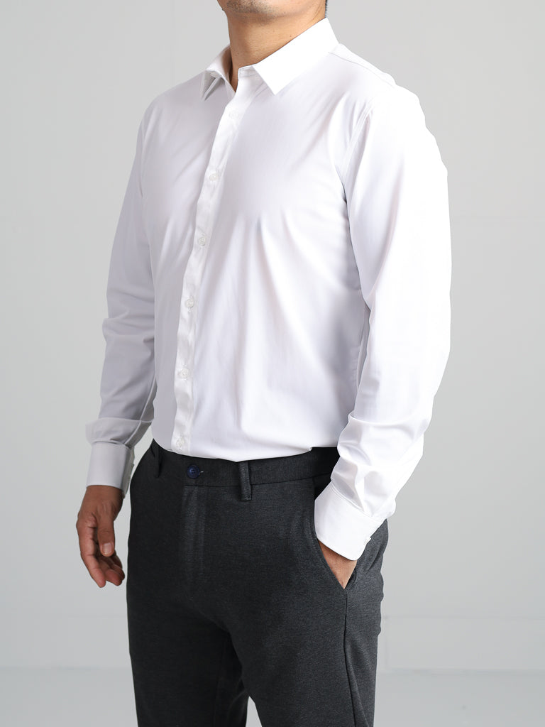 Dressed in an Axel 4-Way Stretch Dress Shirt by ID Menswear and dark trousers, a person stands confidently against a plain background. The slim-fit shirt exudes style and comfort with its 4-way stretch as they pose with their hands at their sides.