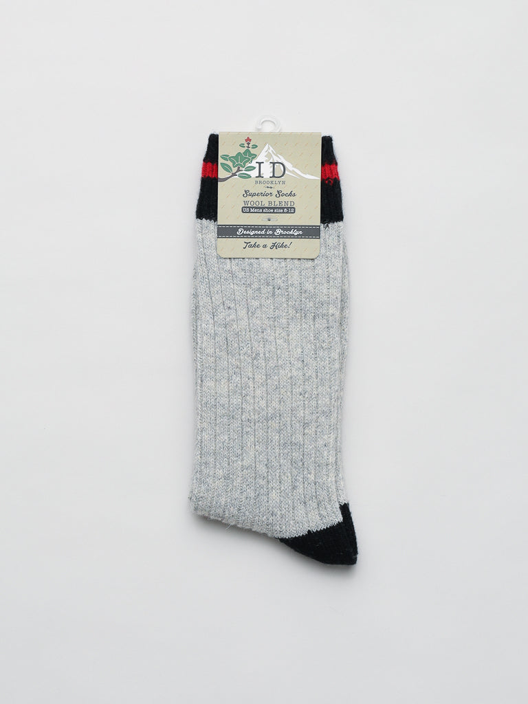 A solitary Wool Blend Sock by ID Menswear features gray wool with black and red accents, packaged with a logo and product details on a cardboard label. Ideal for winter activities, it is stylishly displayed against a plain white background.