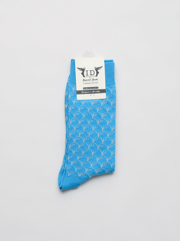 The Broken Waves Graphic Socks by ID Menswear feature a premium comfort fit with a blue color, white scallop pattern, and top label. Made from breathable, stretchy combed cotton, the socks are showcased laid flat on a white background.