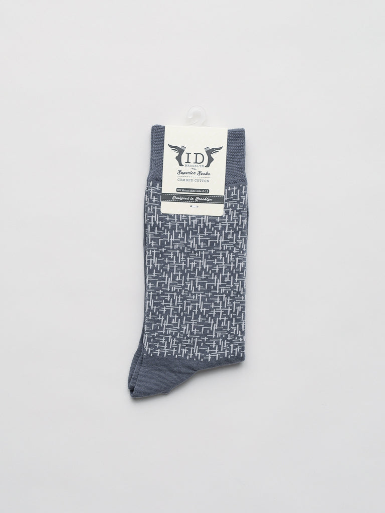 The Urban Graphic Socks by ID Menswear are soft gray combed cotton socks featuring a white geometric pattern. Displayed flat, they have a brand label at the top with a light gray background.