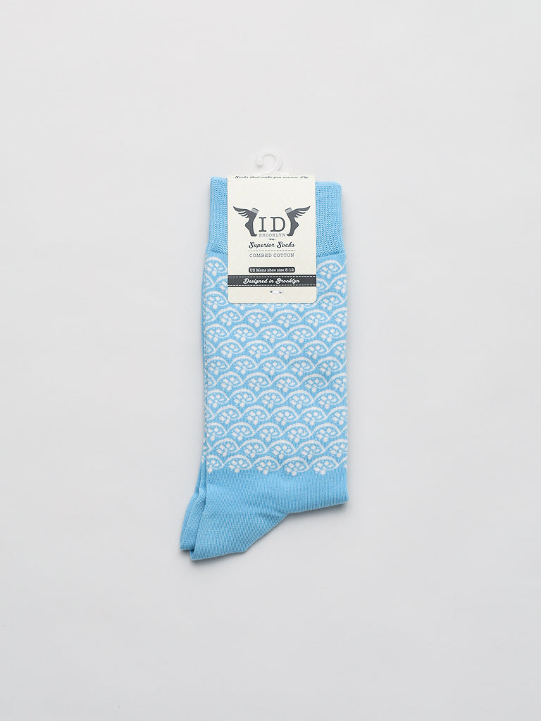 ID Menswears Lotus Graphic Socks, made from soft combed cotton, are presented with a white geometric fan pattern on light blue. They include a decorative label and small hook for convenient hanging.