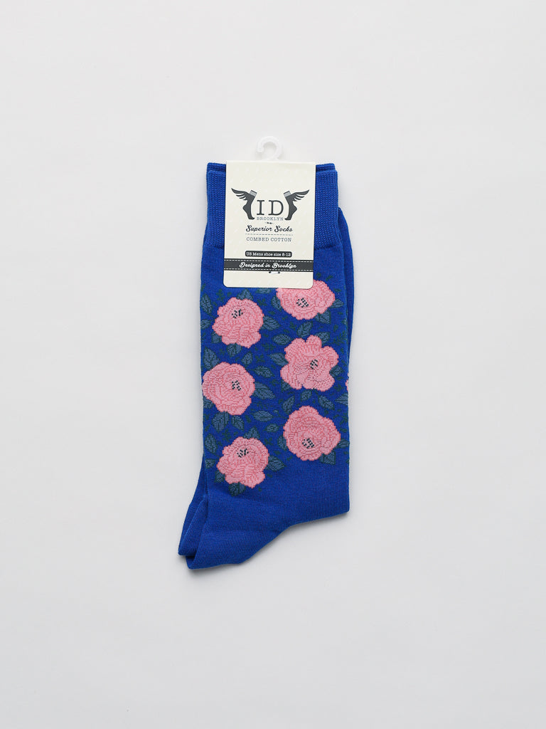 The Roses Graphic Socks by ID Menswear are crafted from premium combed cotton, showcasing a stunning pink floral pattern on a white background with an elegantly attached crisp white label at the top.