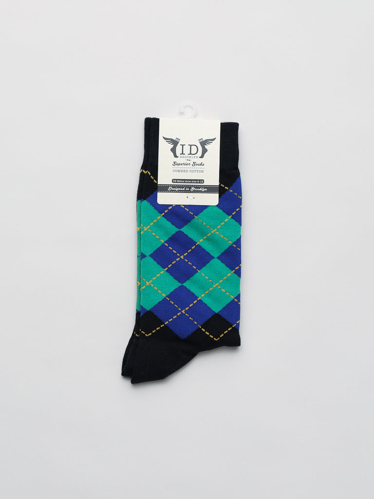 The Argyle Graphic Socks from ID Menswear showcase a classic blue, green, and black argyle pattern on a white base. Made of combed cotton for superior comfort, the socks have the ID Menswear label at the top.