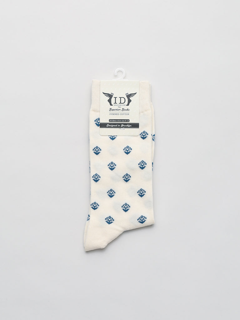 The Mysore Graphic Socks from ID Menswear feature a blue diamond pattern on white, made of breathable combed cotton, and include a small hook for easy display against a plain, light gray background.