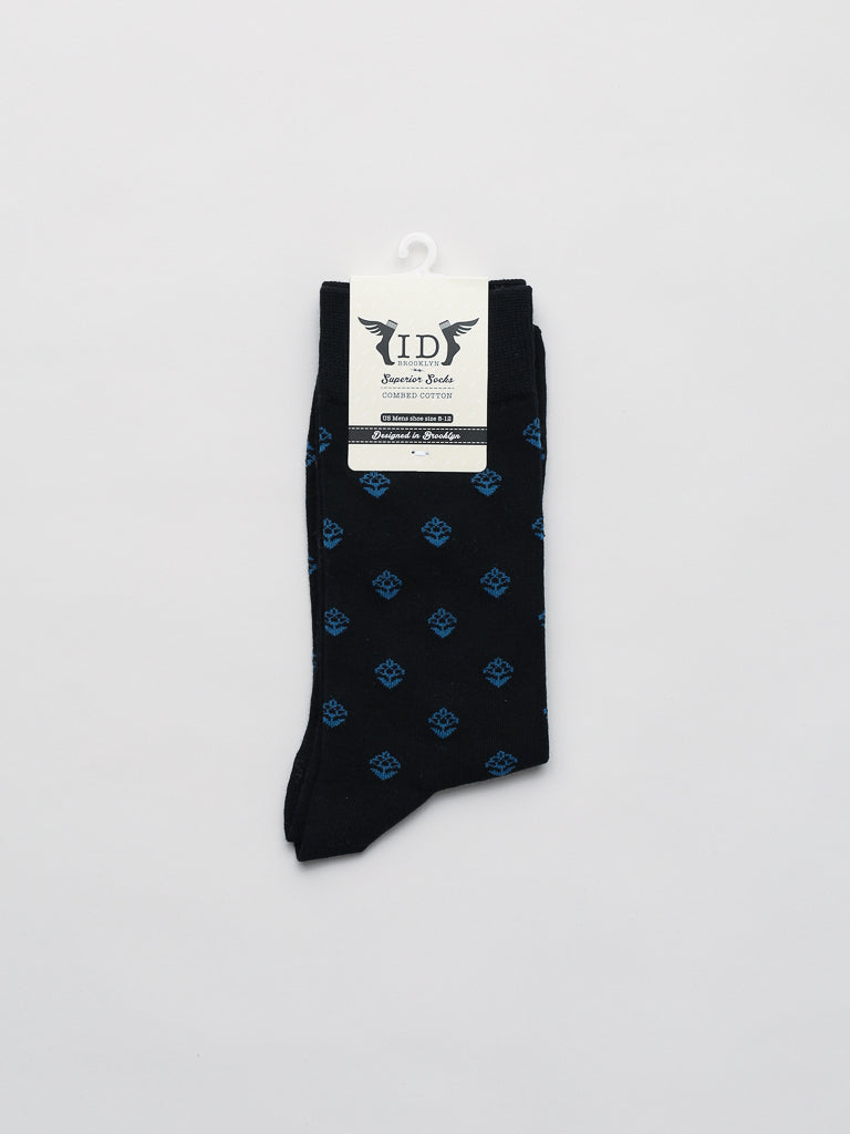 The Mysore Graphic Socks by ID Menswear are displayed on a white background. These black socks feature blue geometric patterns, a breathable combed cotton fabric, and a top white label with text and logo.