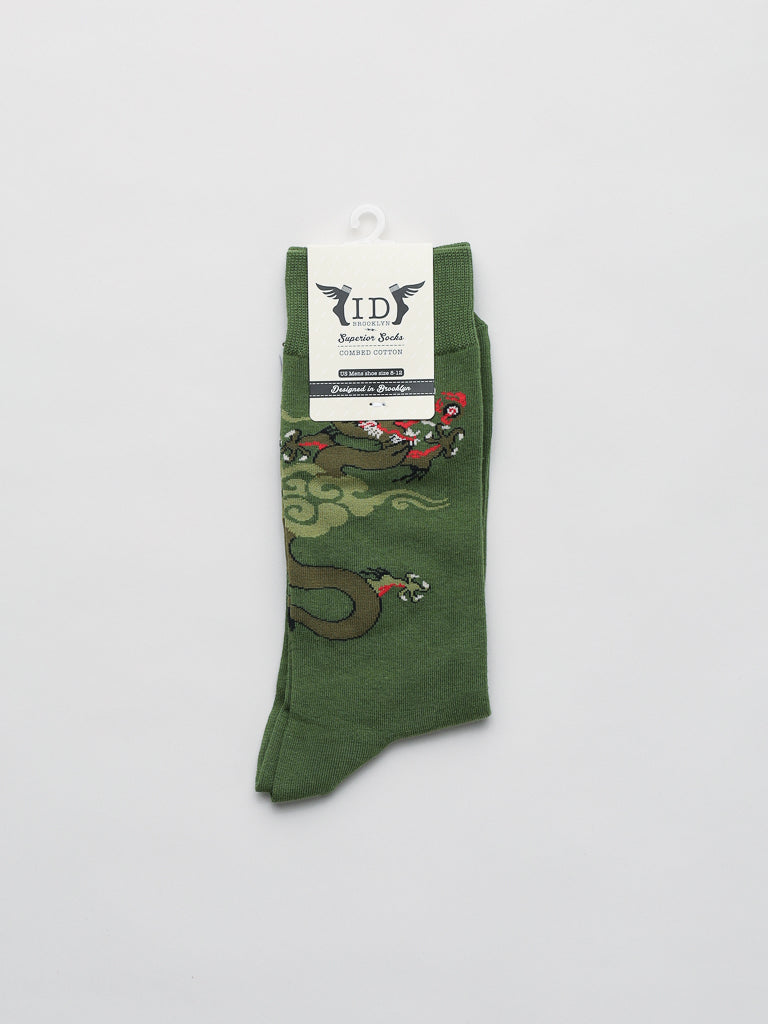 The Dragon Graphic Socks from ID Menswear are made from premium cotton and boast a bold design with a striking dragon motif on a plain background. These green socks feature vibrant red and green hues, neatly folded with a label, epitomizing the Dragon Combed Cotton Socks collection.