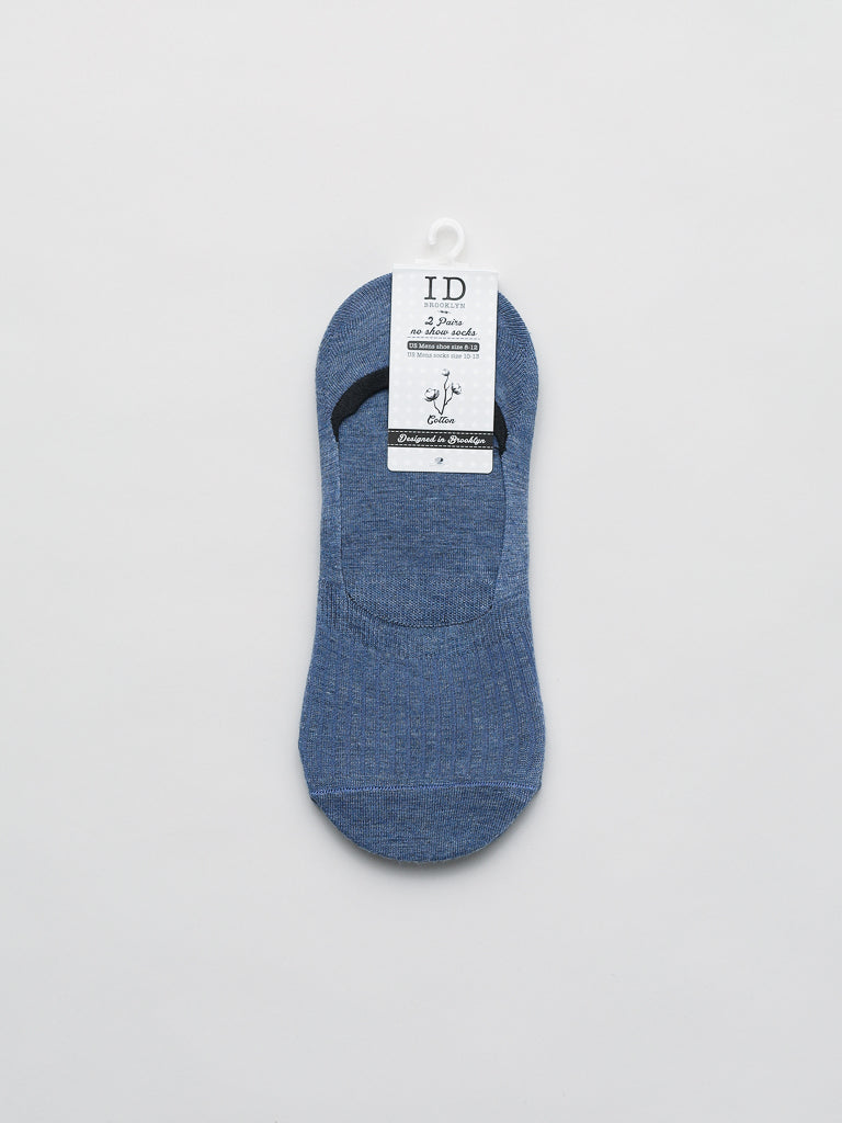 A blue No Show Low Lightweight Sock by ID Menswear is crafted from breathable combed cotton, set on a white background. It features a white hanger tag with text and an illustration of a knife on a boot, highlighting its Fibras de Bambú and Sin Costuras qualities.
