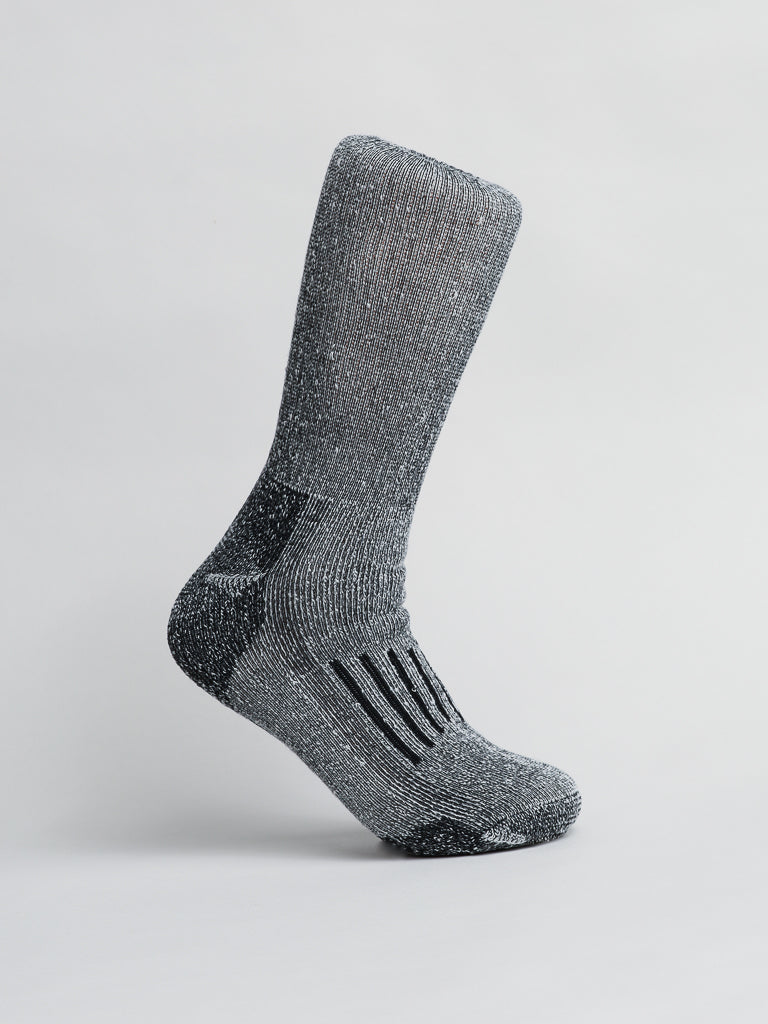 The gray-speckled Merino Wool Blend Sock by ID Menswear stands upright on its toe against a white background. Perfect for cold-weather comfort, it features textured ribbed sections in the middle and a reinforced heel and toe, ensuring breathability and durability.