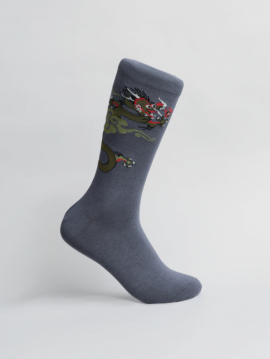 Crafted from premium cotton, ID Menswears Dragon Graphic Socks feature a bold dragon design with intricate scales and vivid red accents against a gray backdrop. Positioned upright, they proudly display the striking artwork, embodying the essence of these socks.