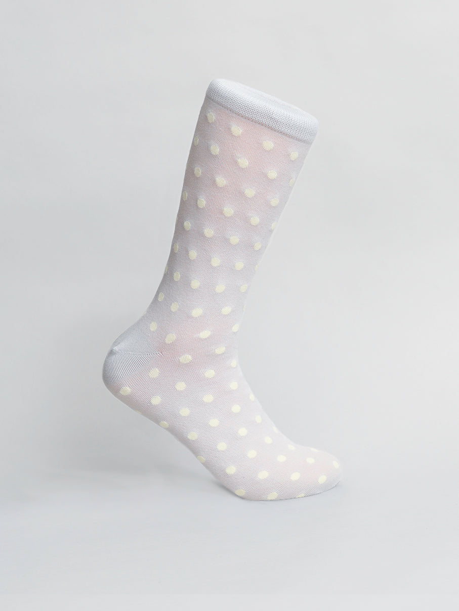 On a neutral background, the Polka Dot Graphic Socks by ID Menswear stand proudly upright, featuring white fabric dotted with pastel yellow spots and made from premium combed cotton for ultimate comfort and stylish charm.