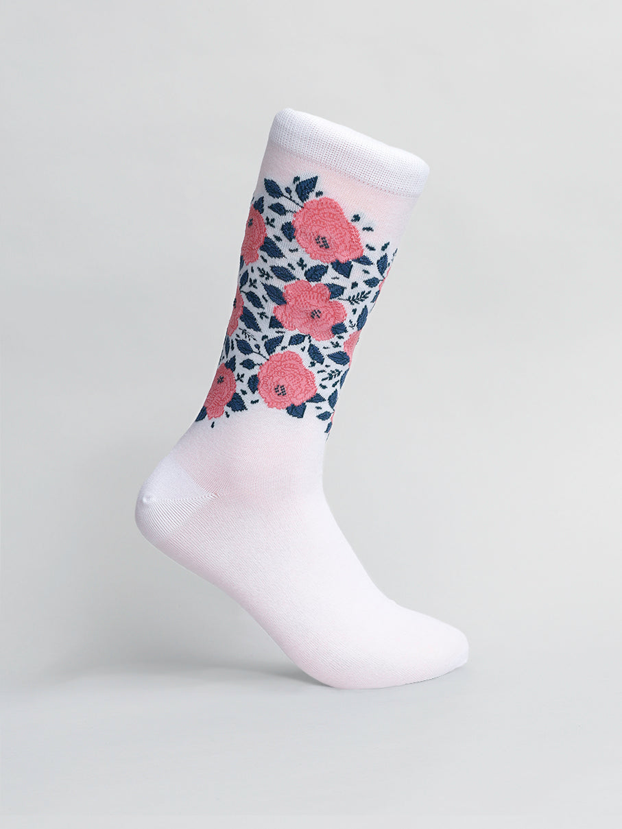 The Roses Graphic Socks by ID Menswear showcase a floral design with pink roses and dark green leaves on the calf, crafted from premium combed cotton for softness. A light gray background adds elegance.