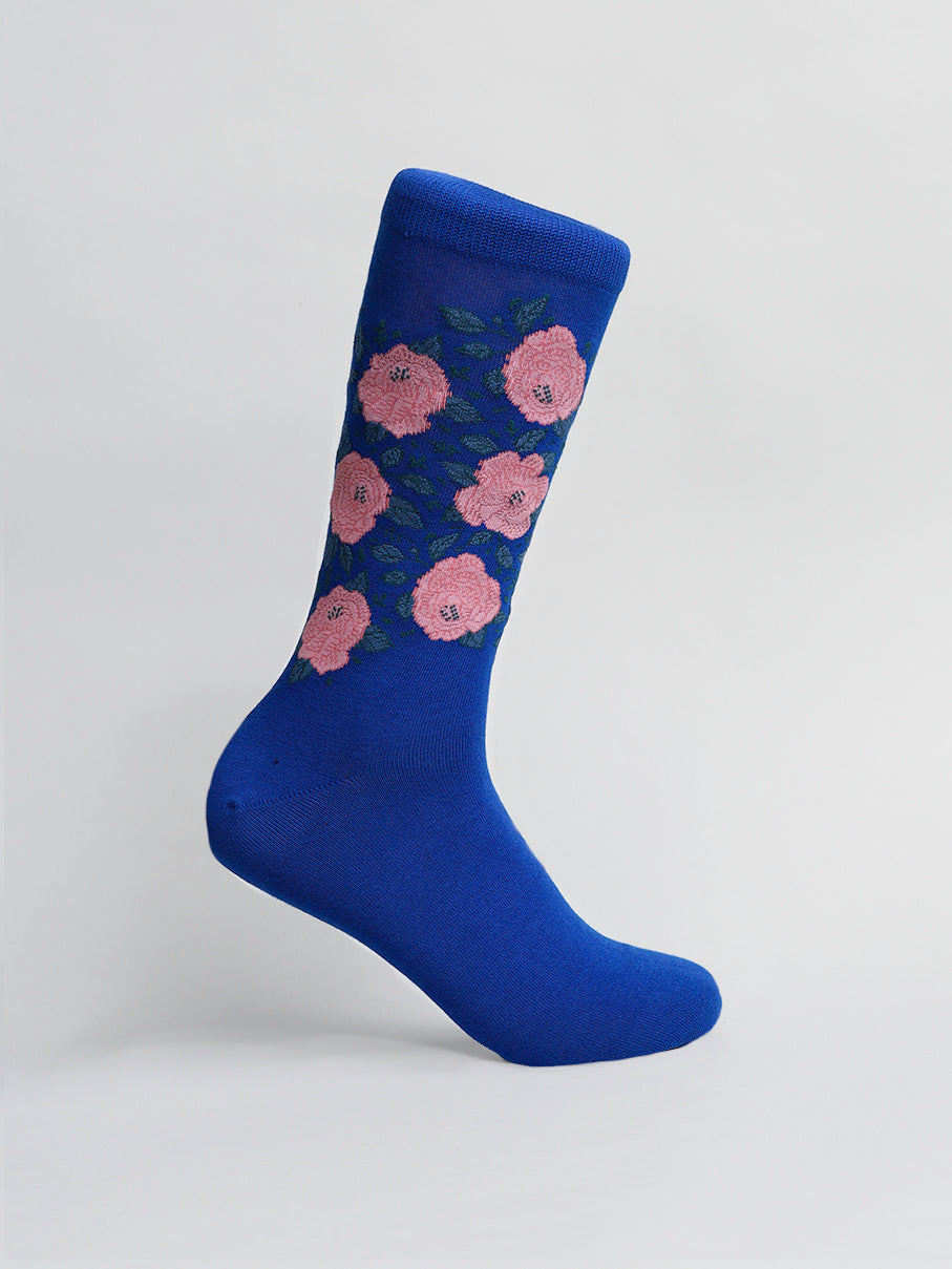 A single blue sock from ID Menswears Roses Graphic Socks collection is shown on a white background. Made of premium combed cotton, it stands upright, displaying elegant pink rose and green leaf patterns.