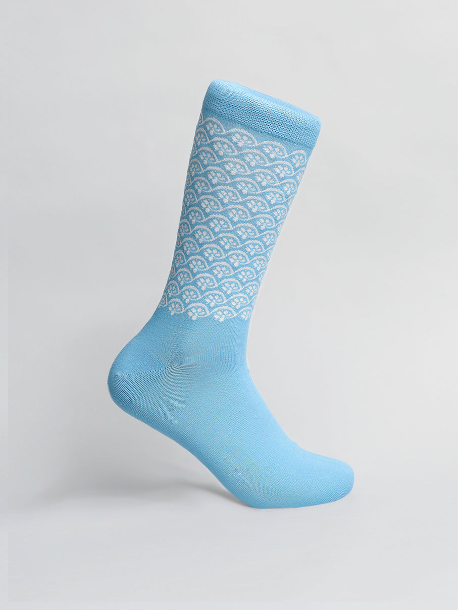 Elevate your style with ID Menswears Lotus Graphic Socks, featuring a light blue color and geometric white patterns on the upper half. Made from breathable combed cotton, theyre showcased on a plain background to highlight their full length and intricate design.