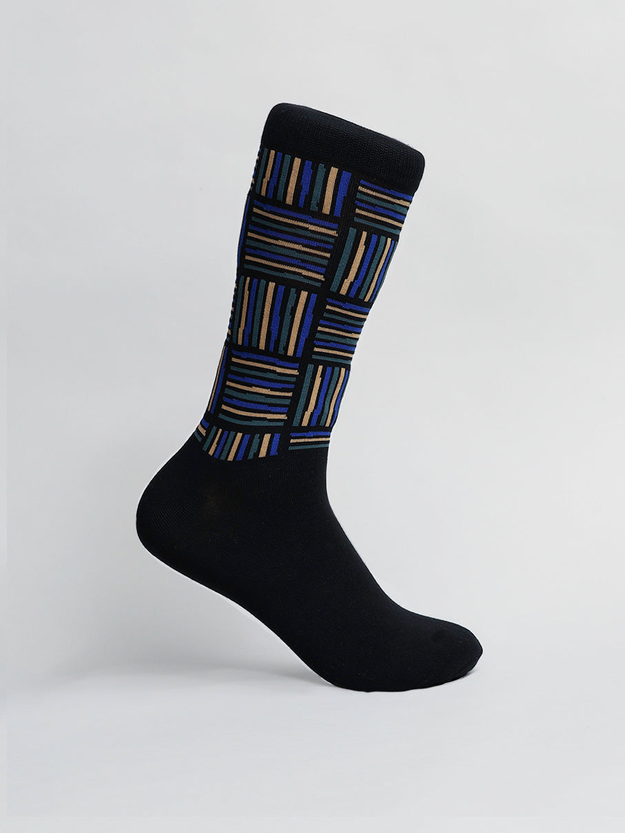 ID Menswears Spongee Graphic Socks feature a distinctive multicolored rectangular design of blue, brown, and tan stripes on the upper part against a solid black foot area. Made from premium combed cotton, these socks offer exceptional comfort and stand out elegantly against a plain white background.