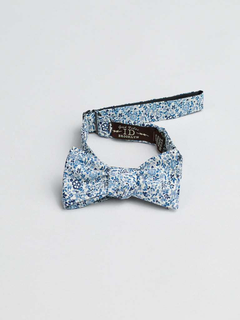 Handmade in Brooklyn, the ID Liberty of London Tana Lawn™ Katie Cotton Bowties by ID Menswear showcase exquisite craftsmanship. Featuring a blue and white floral pattern, these bow ties come with an adjustable strap for a perfect fit against a plain white background.