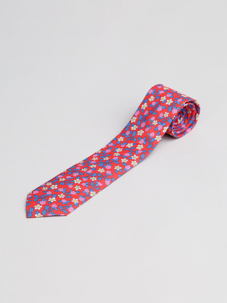 The ID Menswear Liberty of London Tana Lawn™ Strawberries Tie features a colorful floral pattern and is handmade in Brooklyn, shown rolled at one end on a plain light background.