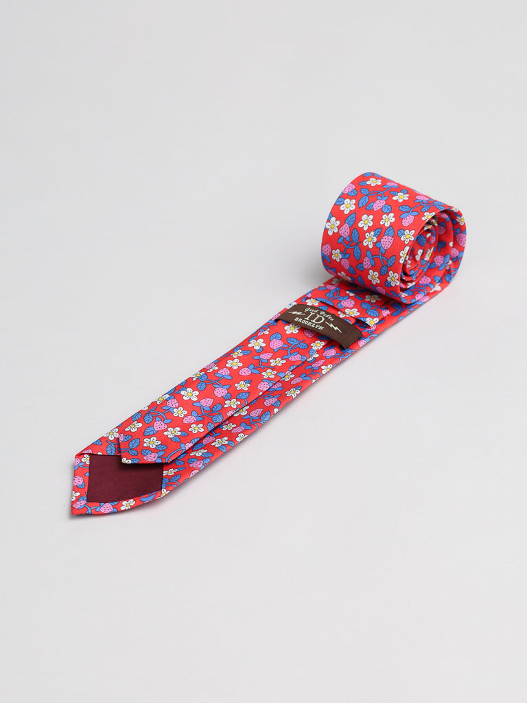 The Liberty of London Tana Lawn™ Strawberries Tie by ID Menswear is rolled up and crafted from Tana Lawn fabric, featuring a charming strawberry pattern on a light background.