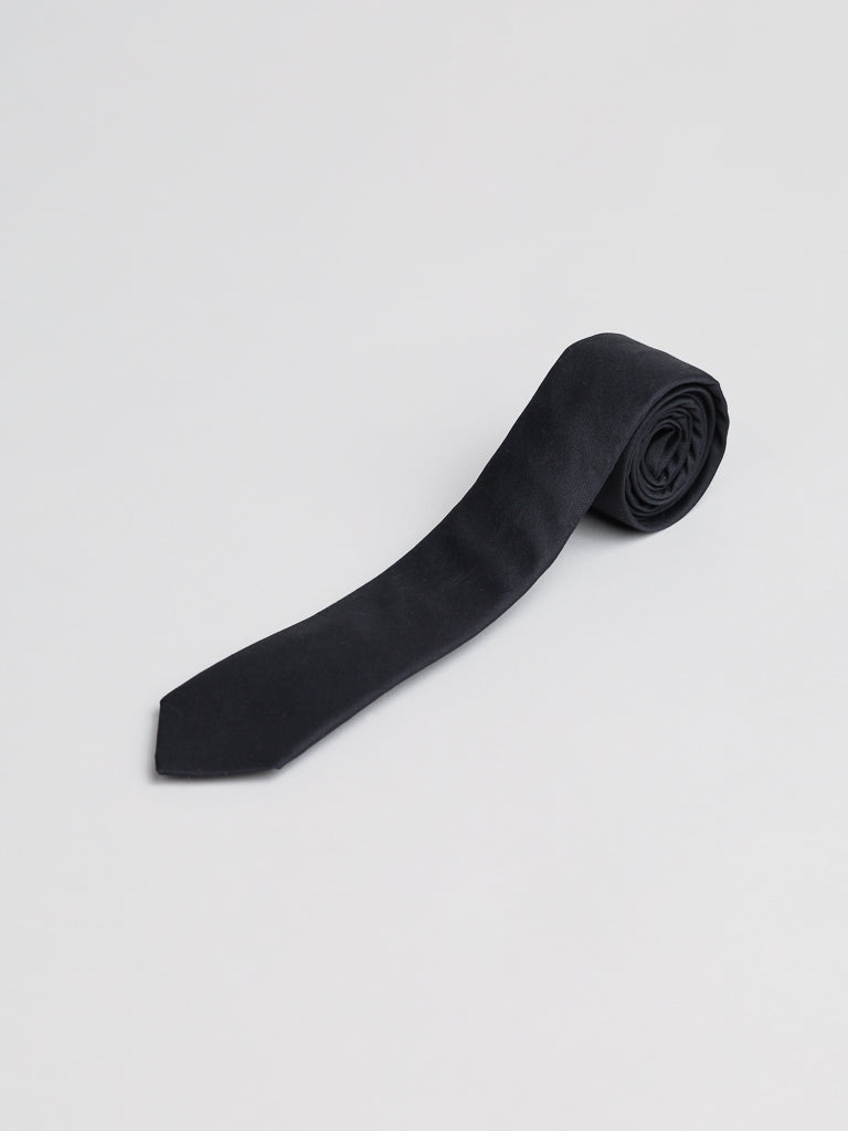 The Super Skinny Cotton Tie by ID Menswear, handmade in Brooklyn from cotton, is shown neatly rolled on a light grey background—ideal for business formal occasions.