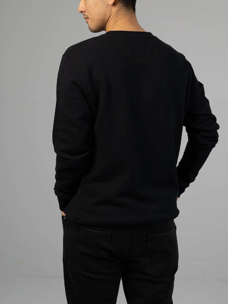 Viewed from behind, a person stands against a gray background wearing an ID Menswear Everyday French Cotton Terry Crewneck Sweatshirt and matching pants, with hands relaxed behind their back.