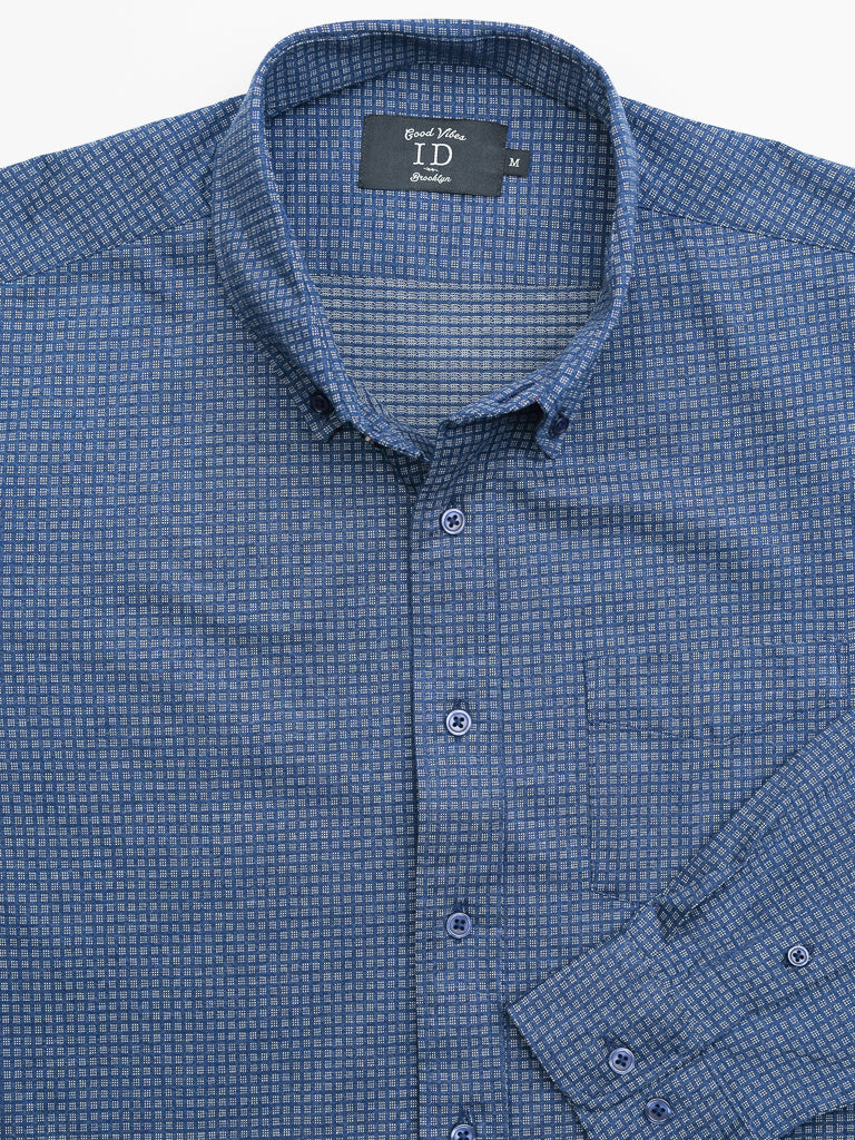 A blue checkered Leo Stretch Button Down Shirt by ID Menswear, featuring a folded collar and long sleeves, is shown on a flat surface. With its high-quality finish and comfortable stretch, it suits any occasion. The label reads Good Vibes ID and Medium.