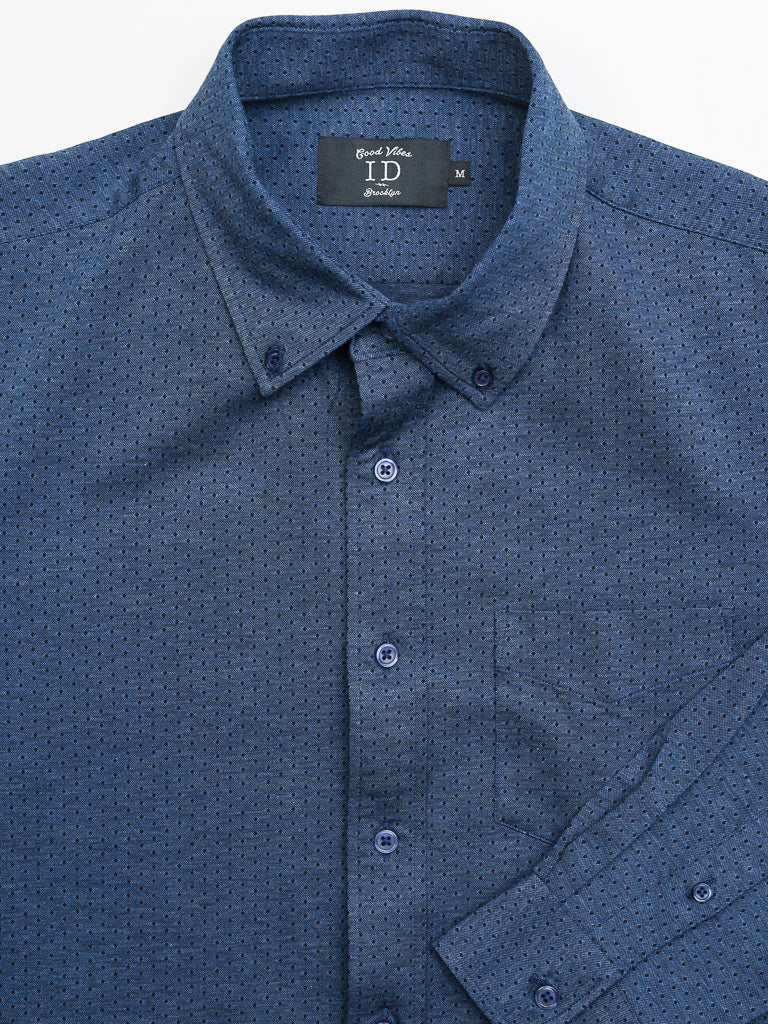 The blue Leo Stretch Button Down Shirt by ID Menswear features a textured pattern, collar, front pocket, and buttons down the front. A label inside the collar reads ID, reflecting its high-quality craftsmanship.