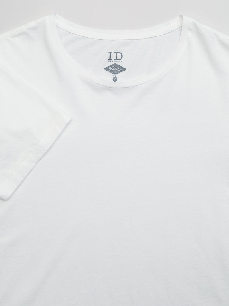 The Legacy Organic Cotton Tee by ID Menswear is a plain white T-shirt with a round neckline made from organic cotton. The logo I.D and 1972 Standard are visible inside the collar.
