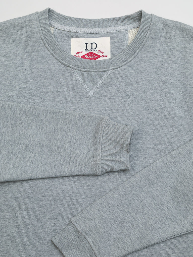 The Everyday French Cotton Terry Crewneck Sweatshirt by ID Menswear features a plush gray fabric, crew neck, and long sleeves. A white neck tag with red and blue text adds a premium touch.