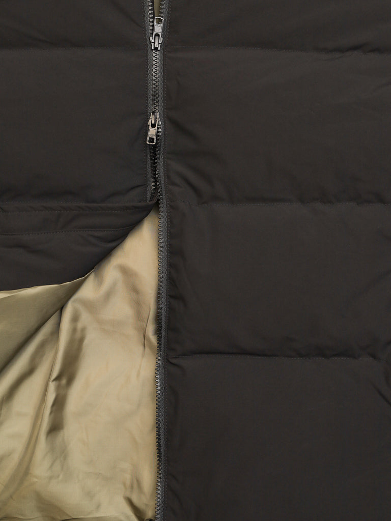 Close-up of the Arctic Black Puffer Down Jacket by ID Menswear, featuring black quilted fabric, a partially unzipped zipper, and a beige inner lining.