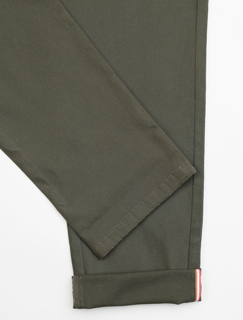 Close-up of ID Menswears Wythe Twill Stretch Chino in slim-fit olive green, featuring a folded hem with a subtle cotton twill texture. Inside the cuff, discover a narrow red, white, and blue stripe detail. The smooth fabric against a white background makes it ideal for casual occasions.