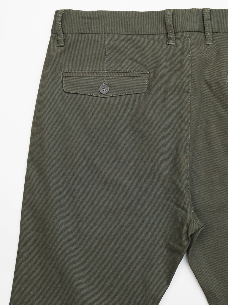 Close-up of Wythe Twill Stretch Chino by ID Menswear in olive green. These slim-fit pants feature a buttoned back pocket, belt loops, and visible seam. Made from textured cotton twill, theyre ideal for casual occasions. The image is set against a white background.