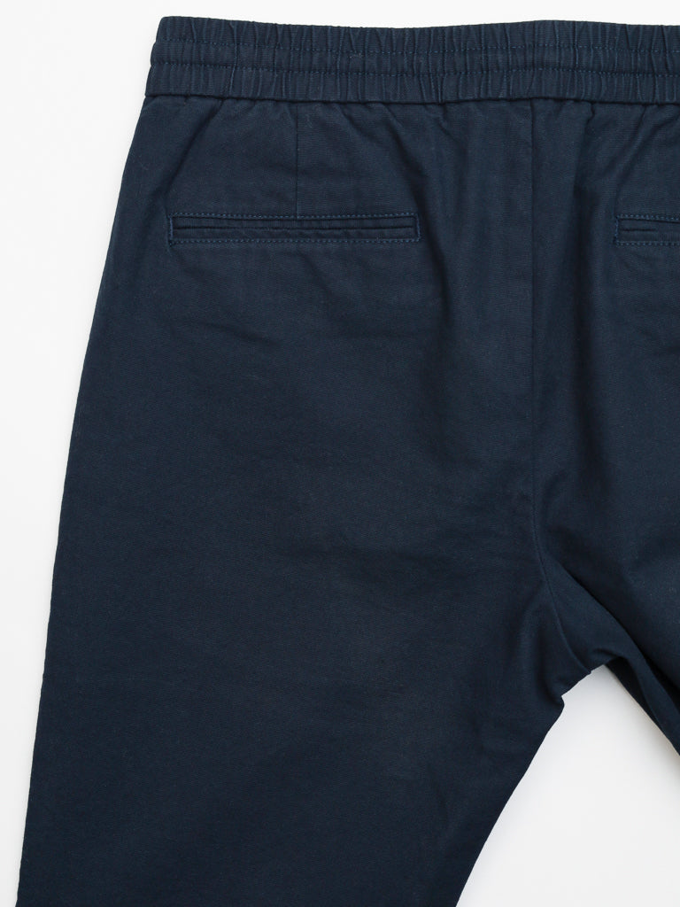 Back view of ID Menswears Kent Drawstring Canvas Pant, featuring a dark blue slim-fit, mid-rise design with an elastic waistband and two welt pockets. The cotton canvas fabric is soft and slightly textured.