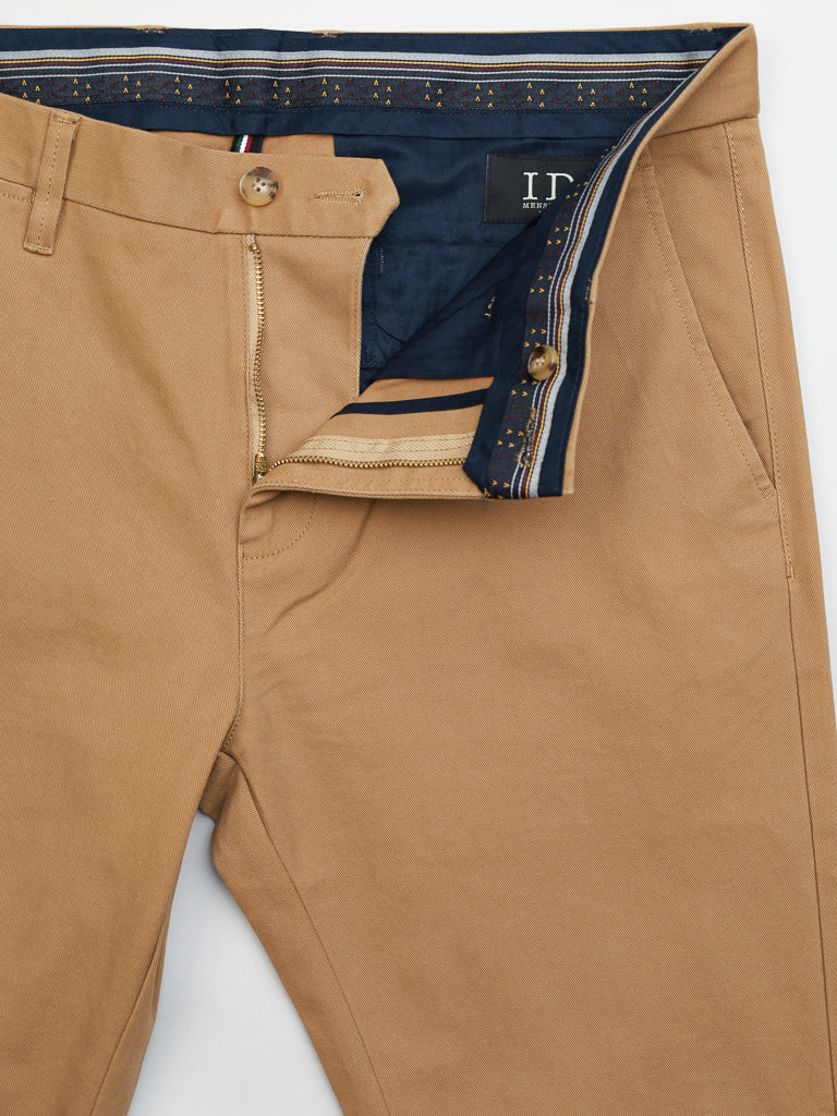 ID Menswears Banker Twill Stretch Chino features a khaki design with an open zipper and button, revealing a navy waistband with gold accents. These mid-rise, regular slim-fit pants include front pockets, belt loops, and a visible tag with letters for effortless elegance.