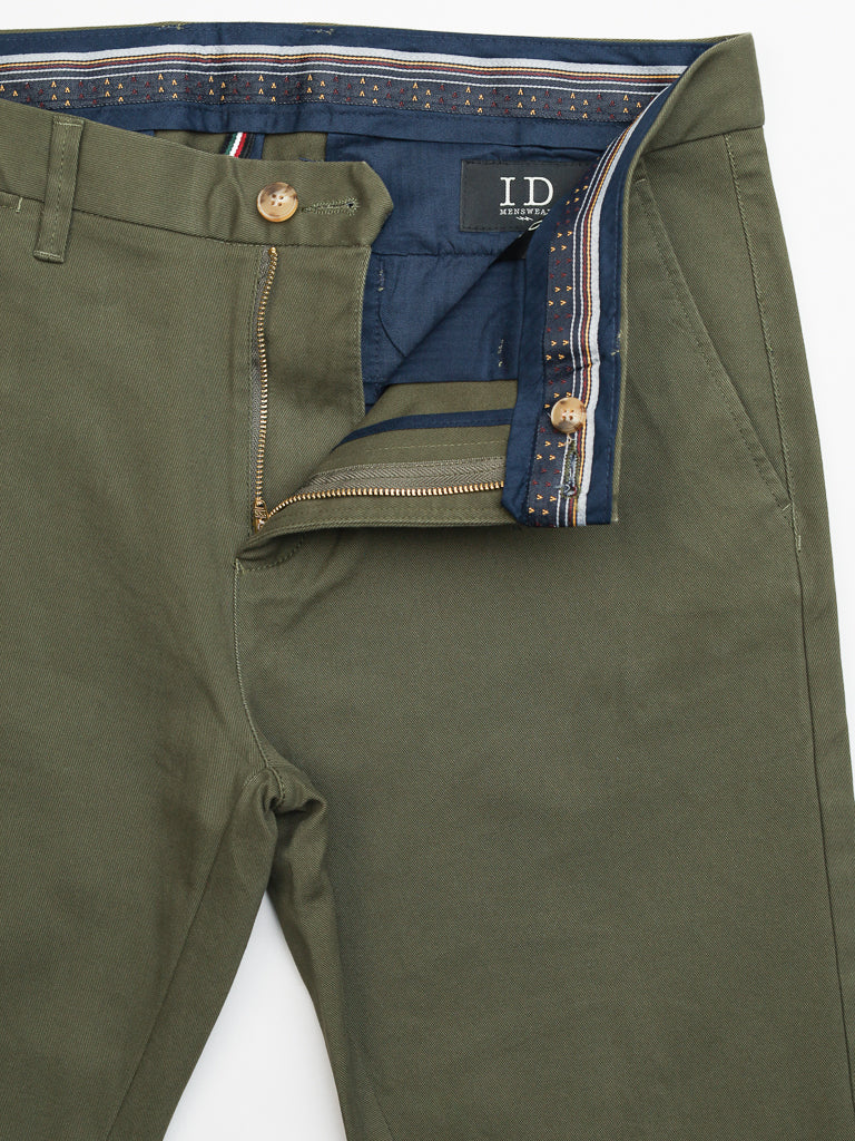 The olive green Banker Twill Stretch Chino by ID Menswear features a partially open metallic zipper and button that reveal a blue inner lining. It has a mid-rise waistband with patterned trim, regular slim-fit design, and includes a black ID label stating Made in India.