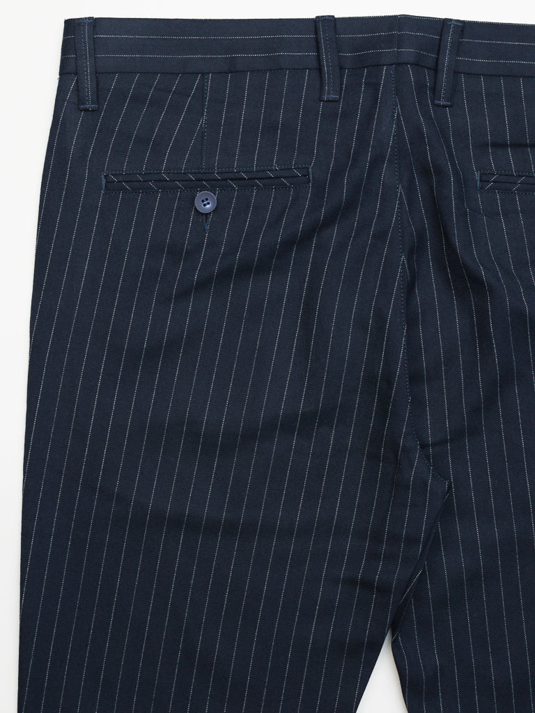 Close-up of ID Menswears Hudson Wool Blend Pin Stripe Pant in navy with white pinstripes, mid-rise, slim-fit design featuring belt loops and two back pockets. One pocket sports a blue button. The pants are elegantly displayed flat against a white background.