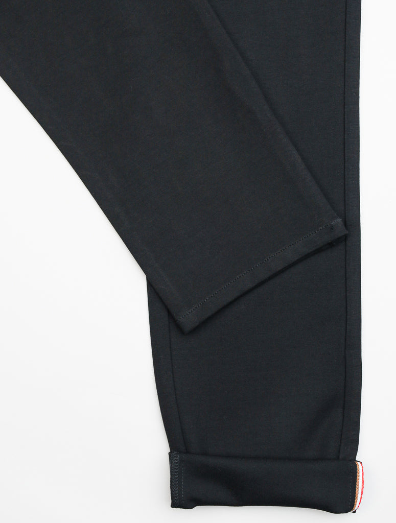 A close-up of the ID Menswear Manhattan 4-way Stretch Dress Pant in black highlights its slim-fit design, visible hem, and detailed stitching. The wrinkle-resistant fabric appears smooth and neatly finished, laid flat against a white background—ideal for business casual wear.