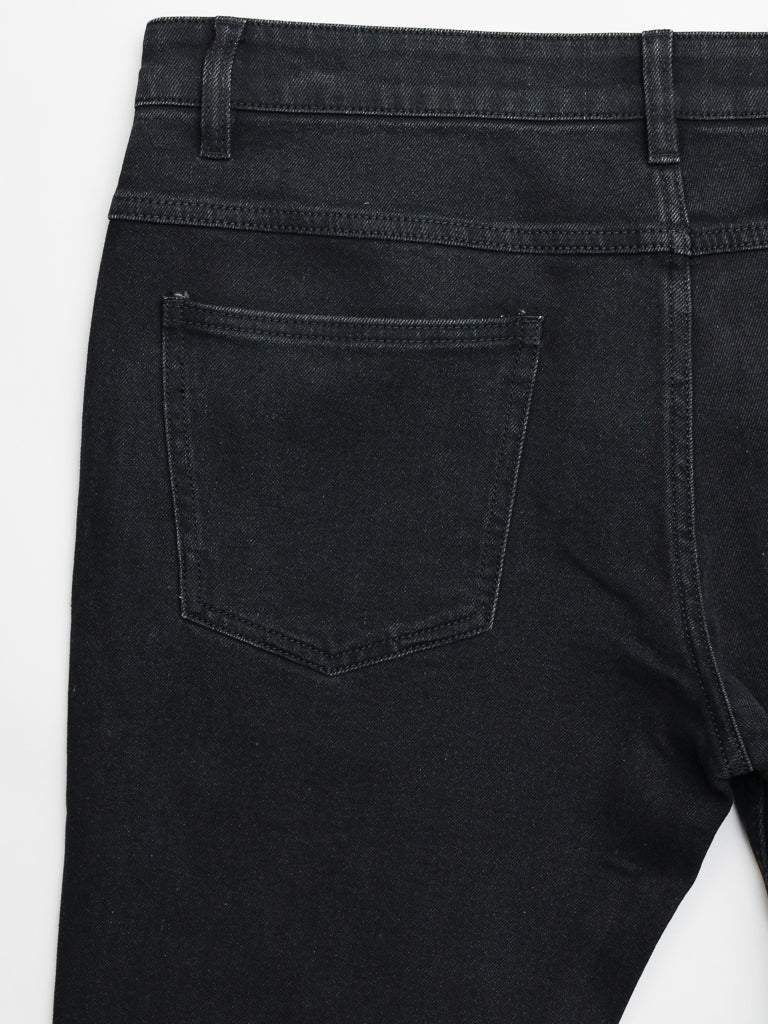 Close-up of ID Menswears Ganbaru Stretch Jean in black cotton twill denim, showing a visible back pocket and belt loops. The slim-tapered fit highlights the fabric texture and stitching against a white background.