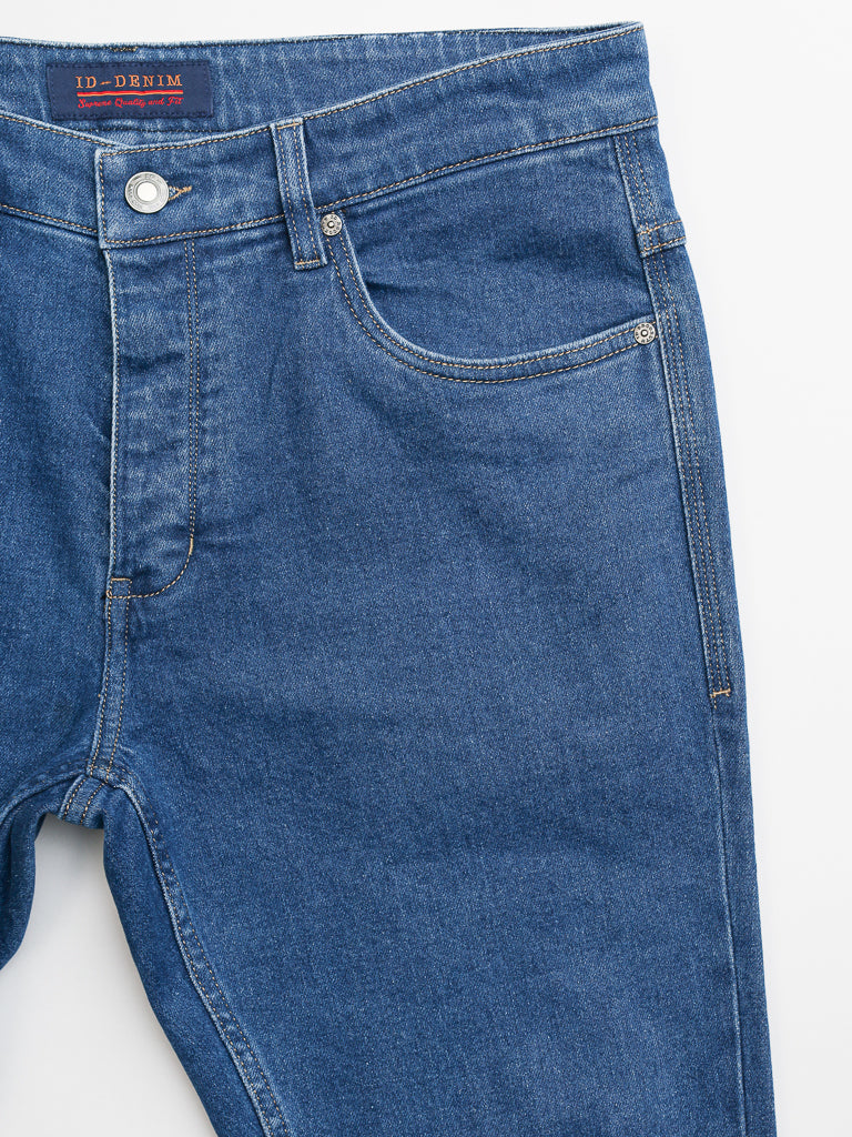 The Ganbaru Stretch Jean by ID Menswear is a pair of slim-tapered blue denim jeans featuring a button closure, small front pocket, and visible stitching. Made from premium cotton twill, they are shown on a white background.