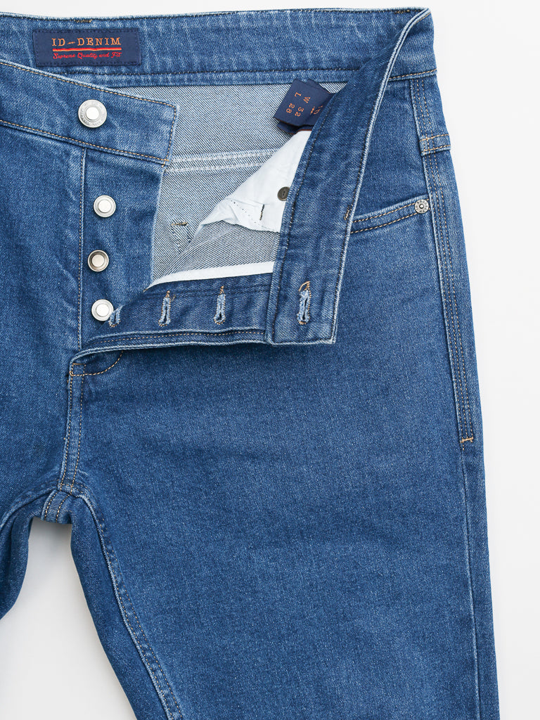 The Ganbaru Stretch Jeans by ID Menswear are shown open from the top, highlighting the interior. They feature a slim-tapered fit with a four-button fly, an inside waistband label, and are made of cotton twill in a classic blue wash.