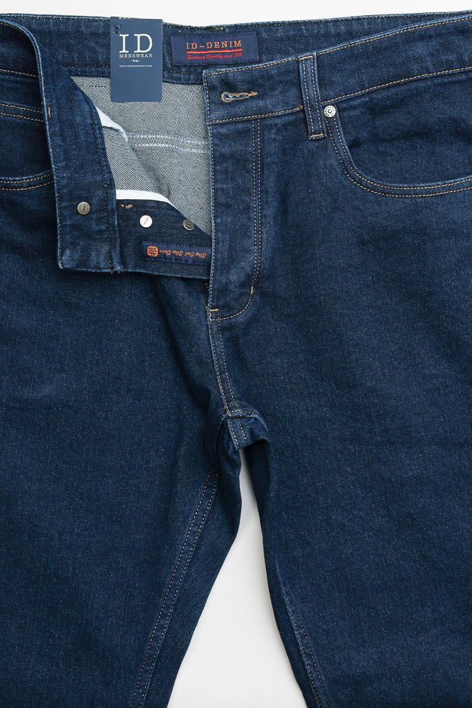 The Ganbaru Stretch Jean by ID Menswear is crafted from dark blue cotton twill denim with a visible waistband label. It features a button closure, partially exposed fly with a white interior tag, slim-tapered fit, classic five-pocket style, and contrast stitching.